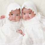 ベビードレスを着た双子の赤ちゃん