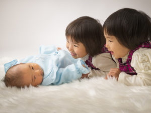 赤ちゃんをあやす姉２人